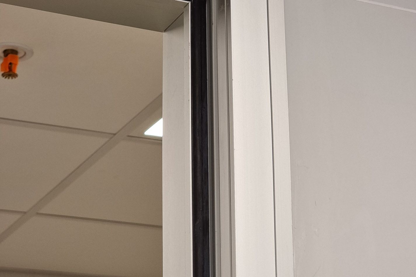 Detalle de una puerta desarrollada a medida: perfil de aluminio, madera y encastre resueltos en planta.
