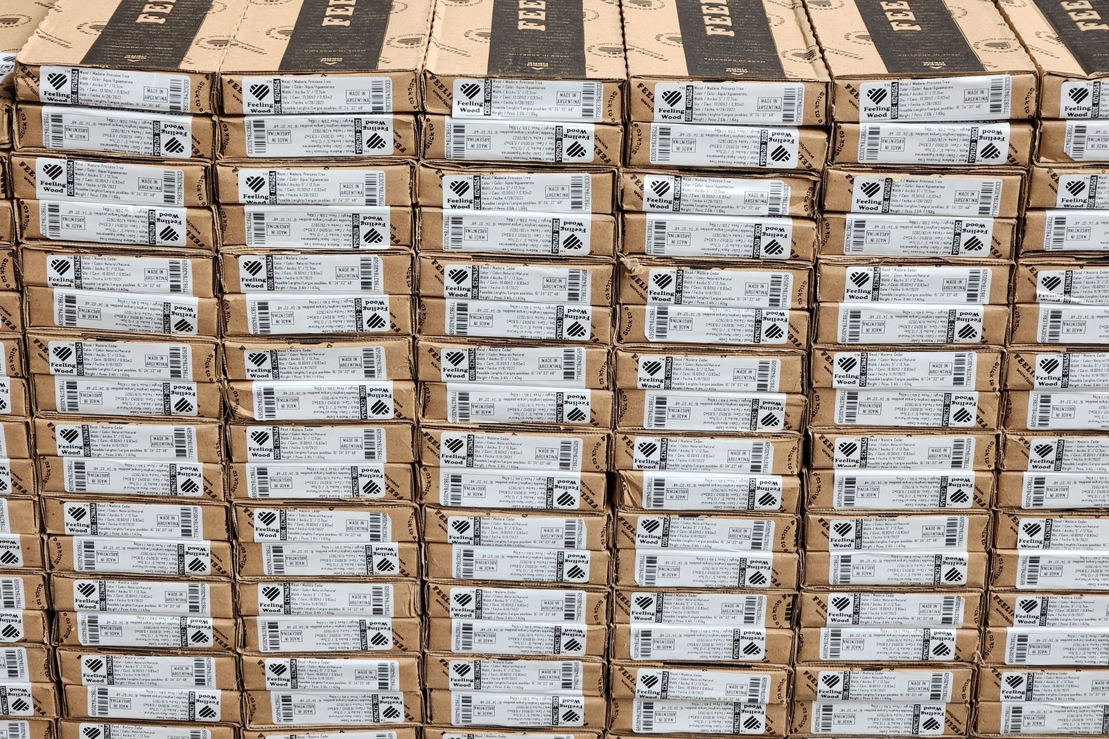 Pallet con cientos de cajas idénticas etiquetadas: producción en serie estandarizada, lista para despacho con la marca del cliente.